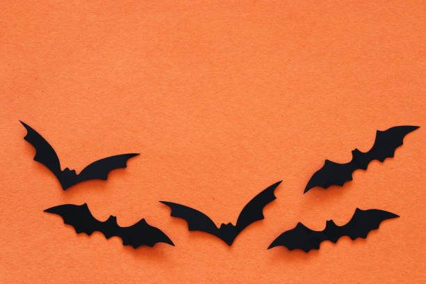 istock Halloween holiday concept. Black bats over orange background. Top view, flat lay. 1029794498