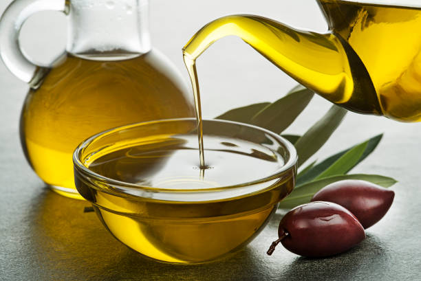 bottle of olive oil pouring - olive oil pouring antioxidant liquid imagens e fotografias de stock