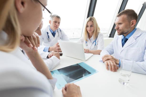 istock Group of doctors discuss x-ray 1029807908