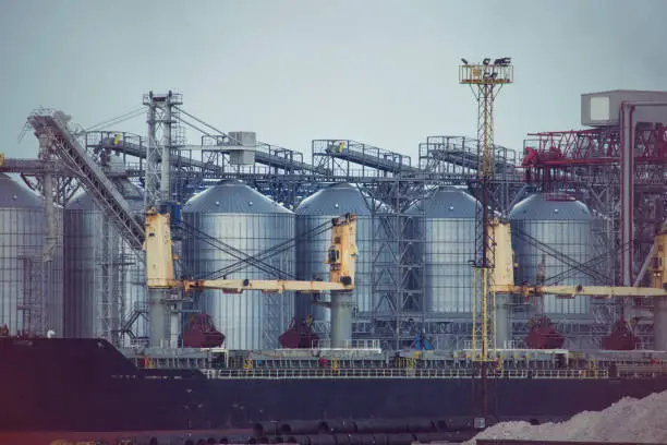 Photo of Port grain elevator. Industrial sea trading port bulk cargo zone grain terminal