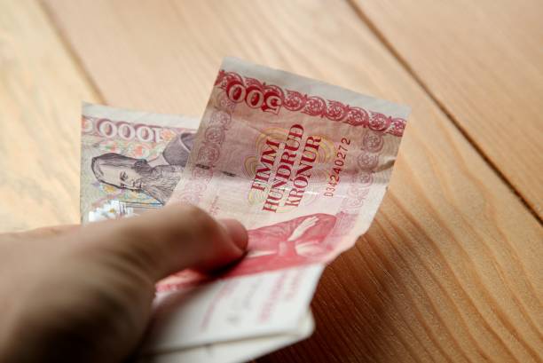 istock Hand holding Icelandic Kroner bank notes (cash). 1029814842