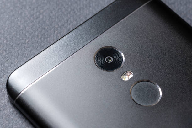 istock Black smartphone on a black textured surface is the back side 1029817788