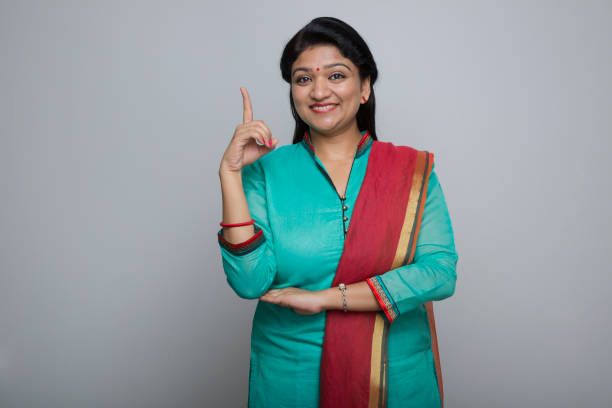 istock Smiling young woman showing blank copy space - Stock image 1029822874