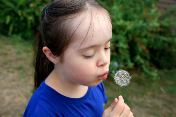 istock Little girl blowing dandelion 1029827018