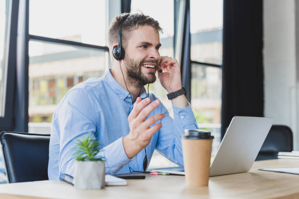 istock smiling young call center operator in headset working with laptop in office 1029830820