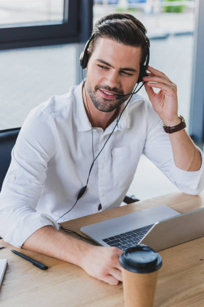 istock smiling young call center operator in headset using laptop in office 1029830860