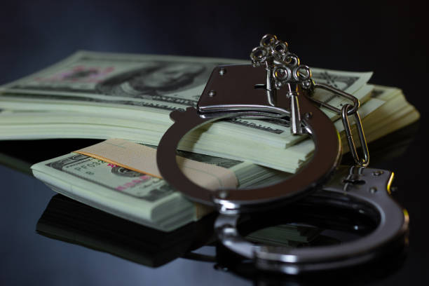 istock Handcuffs and money in the darkness. 1029844840