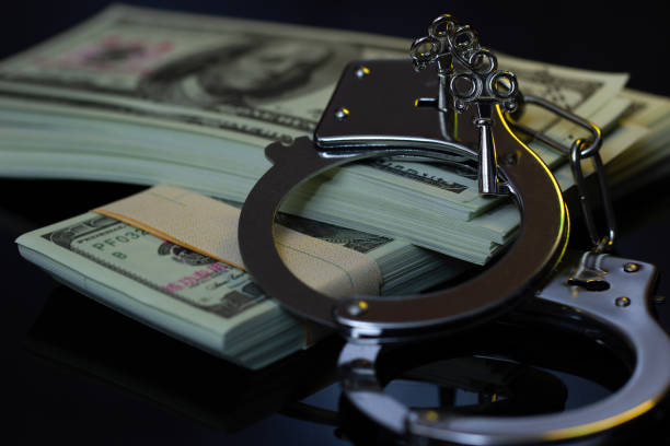 istock Handcuffs and money in the darkness. 1029844874
