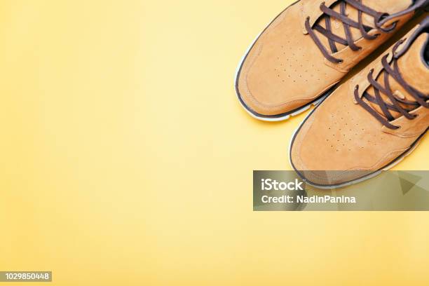 Brown Boots On Yellow Background Copyspace Flat Lay Stock Photo - Download Image Now
