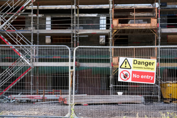 istock Unstable building keep out dangerous sign on fence at building construction site 1029855206