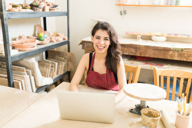 istock Confident Artisan Working On Laptop In Pottery Workshop 1029856294
