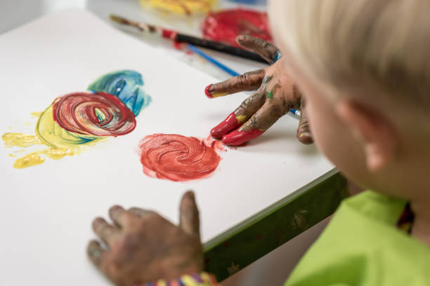 Little boy having fun painting with fingers