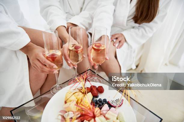 Foto de Meninas Em Roupões Segurando Copos De Champanhe Com Morangos e mais fotos de stock de Spa