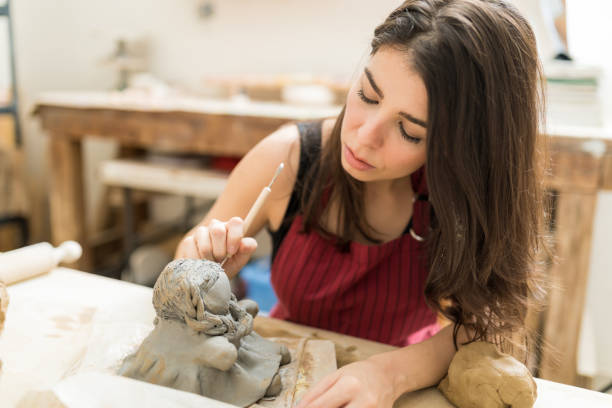 istock Pottery Master Giving Clay A Shape Of Doll In Studio 1029864614