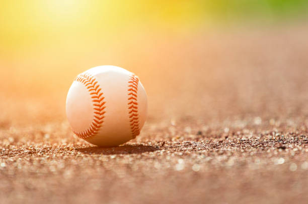 istock Baseball ball on pitchers mound. Baseball field at sunset 1029864806