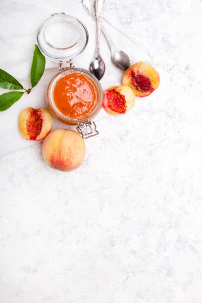 homemade peach jam with organic fruit. sweet preserves on a light background, copy space - preserves jar apricot marmalade imagens e fotografias de stock