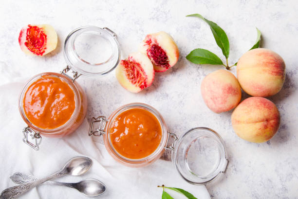 homemade peach jam with organic fruit. sweet preserves on a light background - preserves jar apricot marmalade imagens e fotografias de stock