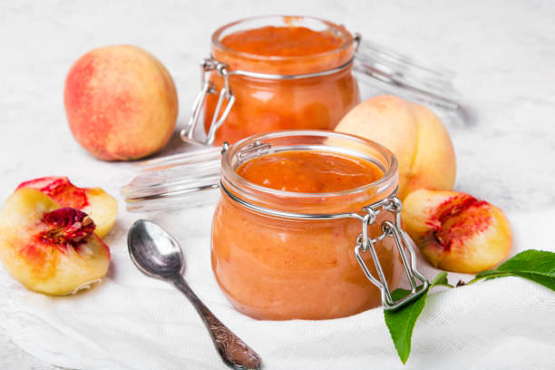 homemade peach jam with organic fruit. sweet preserves on a light background - preserves jar apricot marmalade imagens e fotografias de stock