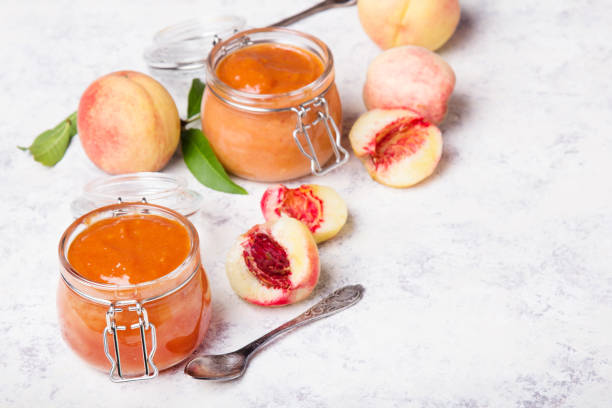домашнее персиковое варенье с органическими фруктами. сладкие консервы на светлом фоне, копирование пространства - preserves jar apricot marmalade стоковые фото и изображения