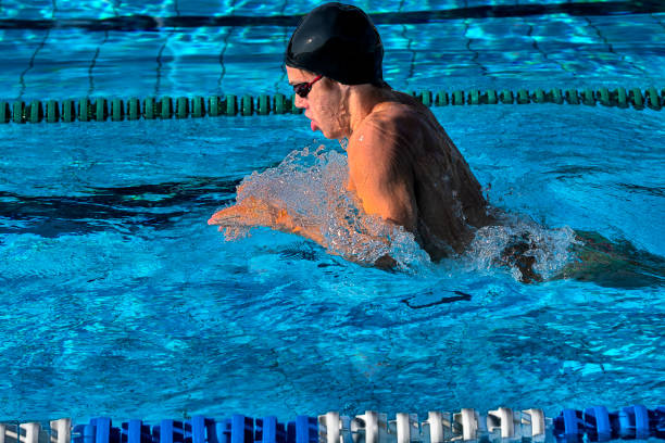 Side view of teenager at breaststroke swimming outdoors