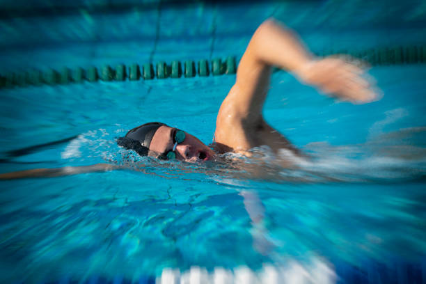 istock Young Man Swimming Freestyle in the Swimming Pool 1029888444