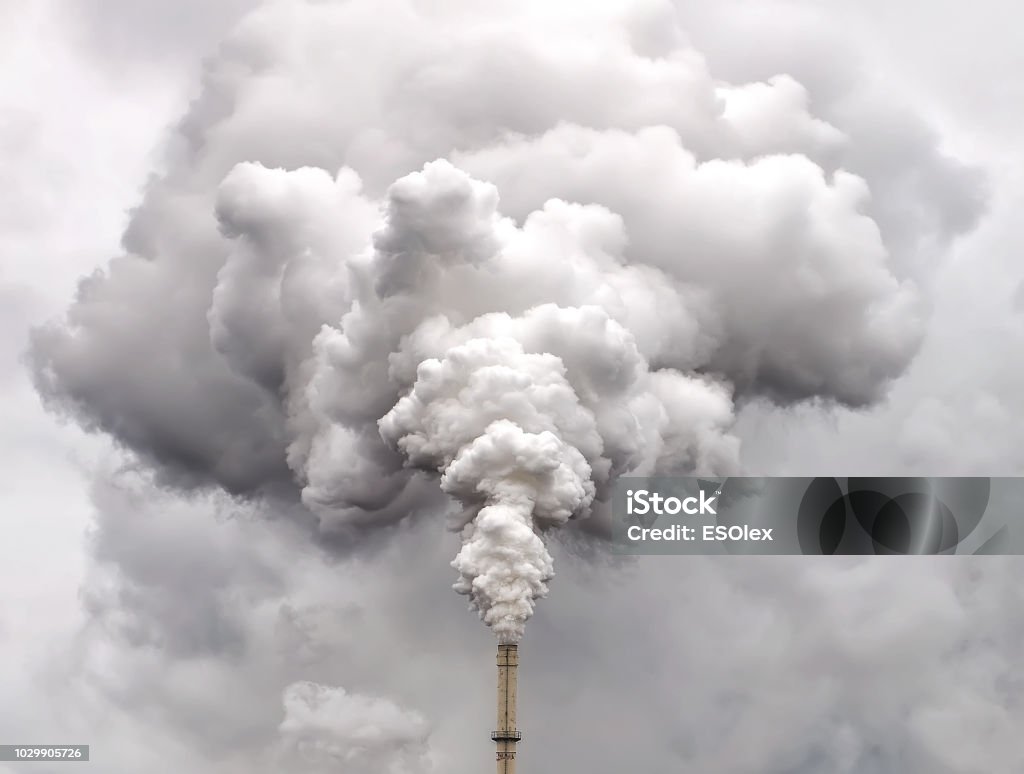 Smoke from factory pipe against dark overcast sky Pollution Stock Photo