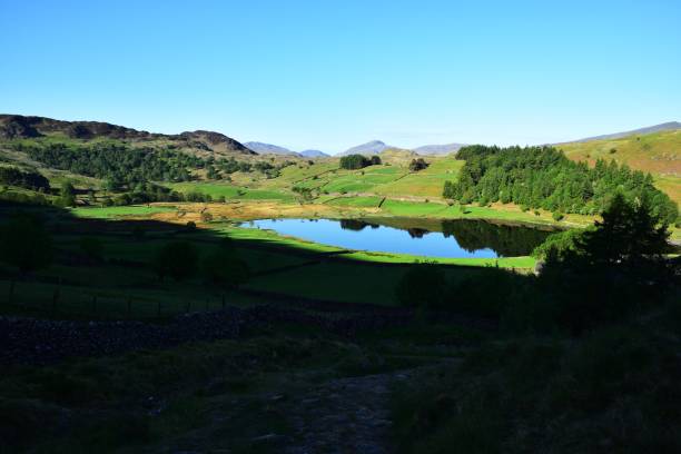 flat calm on watendlath tarn - watendlath imagens e fotografias de stock