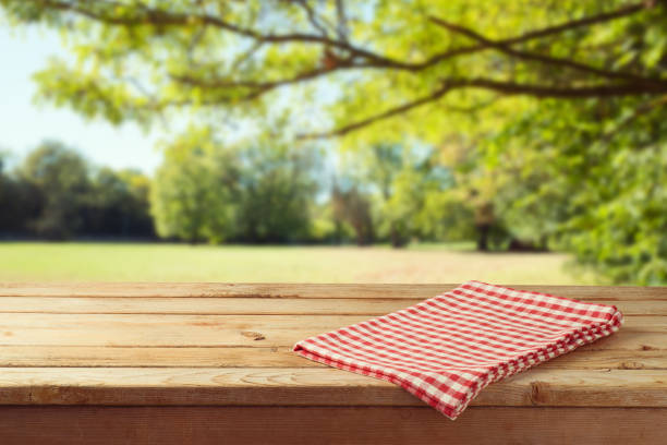 empty wooden table with tablecloth over autumn nature park background - checked textile imagens e fotografias de stock