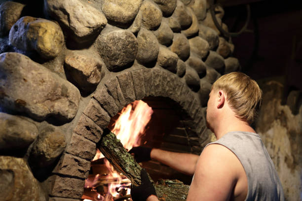 istock Person kindles fire in fireplace 1029915504