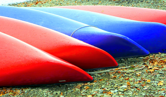 Colorful beached canoes on the banks of Derwent Water, Lake District National Park, Cumbria, England, UK.