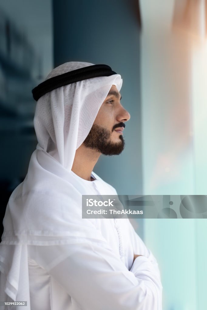 Arab men looking Arab men looking outside window United Arab Emirates Stock Photo