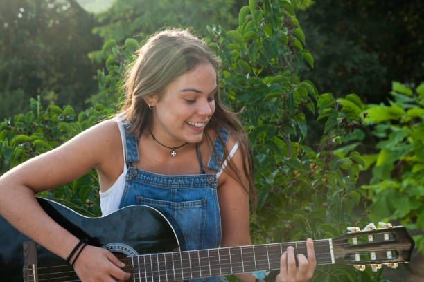 istock Young woman playing guitar 1029942924