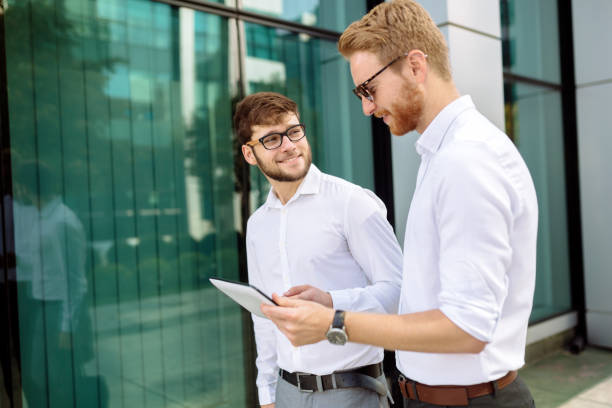 istock Businesspeople looking at tablet outdoors 1029944132