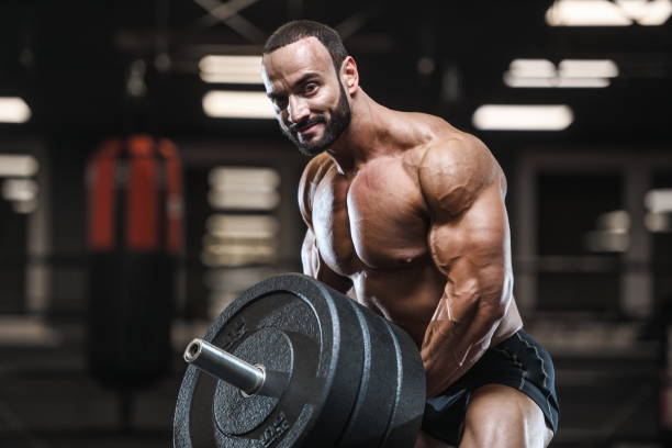 istock Brutal strong bodybuilder athletic men pumping up muscles with dumbbells 1029955324