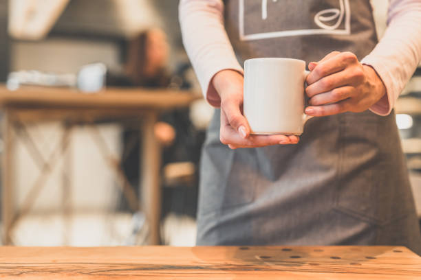 istock The waitress holding a white cup in a cafe 1029955660