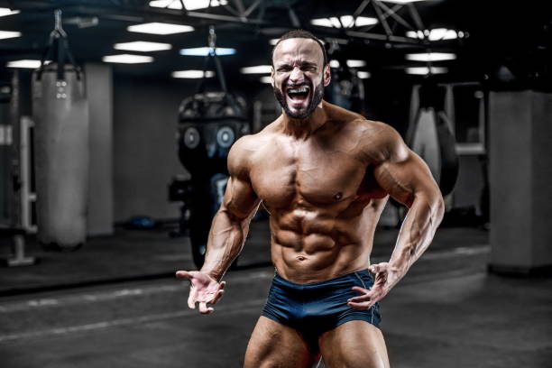 istock Brutal strong bodybuilder athletic men pumping up muscles with dumbbells 1029962366