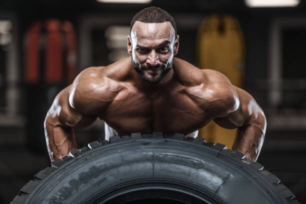 istock Brutal strong bodybuilder athletic men pumping up muscles with dumbbells 1029962854