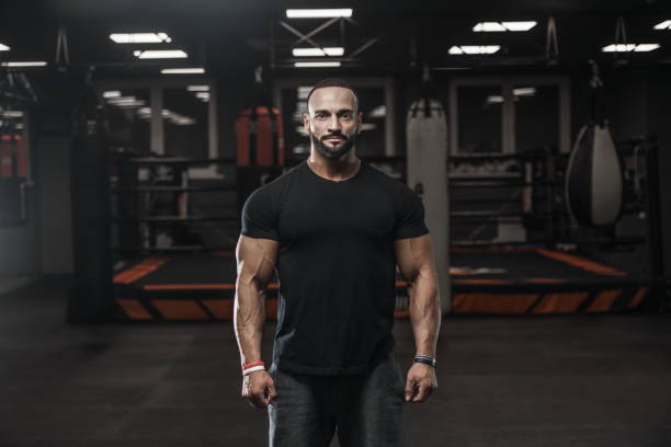 istock Brutal strong bodybuilder athletic men pumping up muscles with dumbbells 1029965676
