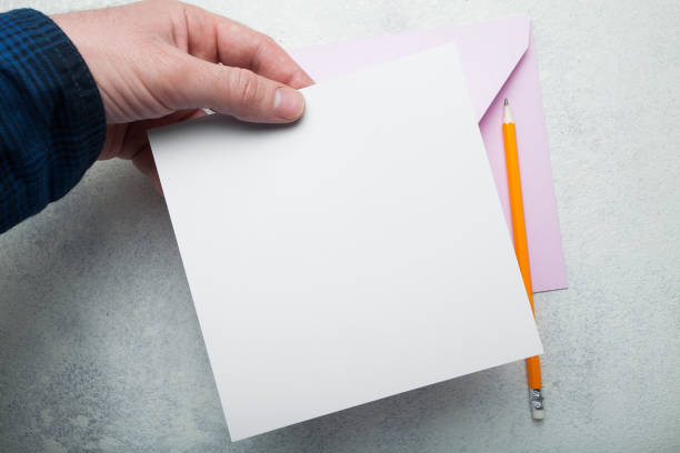 istock square invitation for a holiday in the hand on a white background 1029974672