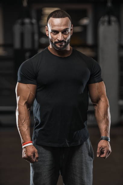 istock Brutal strong bodybuilder athletic men pumping up muscles with dumbbells 1029975120