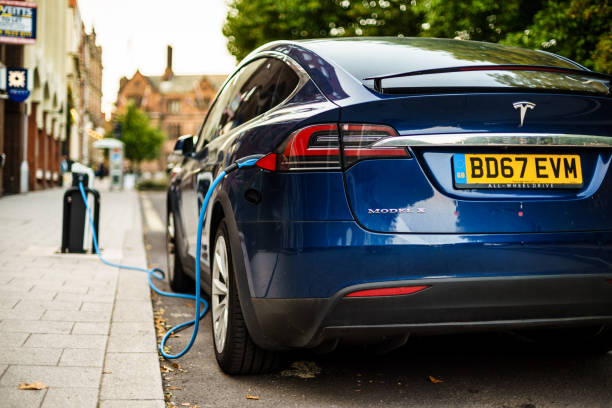 Tesla Charging on street in Coventry UK. Coventry, UK - August 31, 2018: Coventry City Centre Tesla electric vehicle parking area and charging from street electrical dock. tesla model x stock pictures, royalty-free photos & images