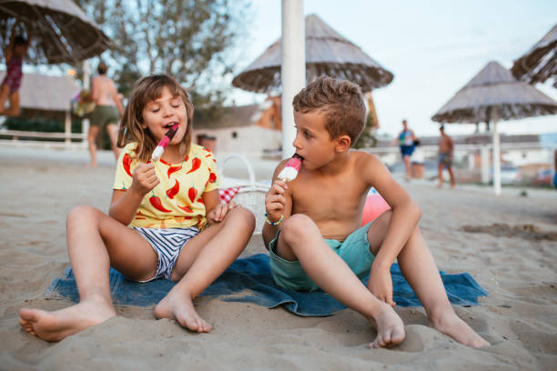 istock Happy kids eating ice cream on the beach 1030001628