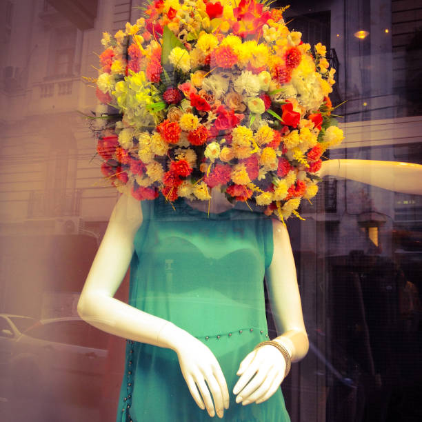 Buenos Aires, Argentina - August 28, 2014: mannequin in store window with its head covered with ball of flowers to announce the spring season. The city has has lots of fashion stores with very creative displays