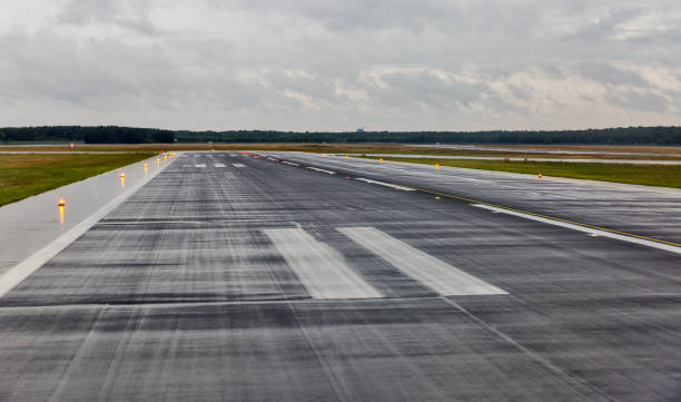 empty runway at the passenger airport in the rain empty runway at the passenger airport in the rain with cloudy airfield stock pictures, royalty-free photos & images