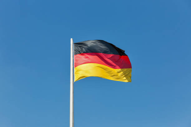 German flag on the flagstaff waving against clear blue sky German flag on the flagstaff waving against clear blue sky at sunnt day german flag stock pictures, royalty-free photos & images