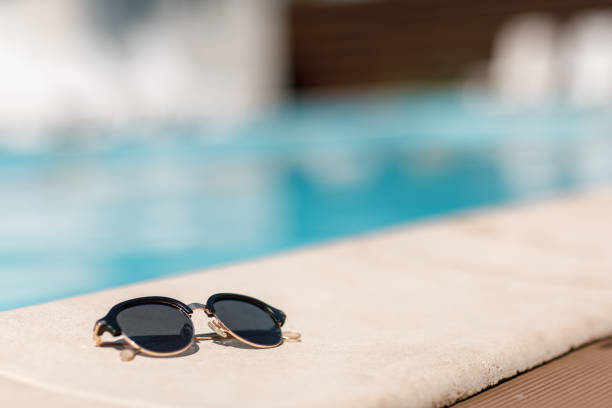 sunglasses by the pool on a sunny summer day. summer background.