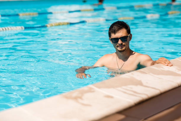 istock young man in sunglasses in the pool 1030015940