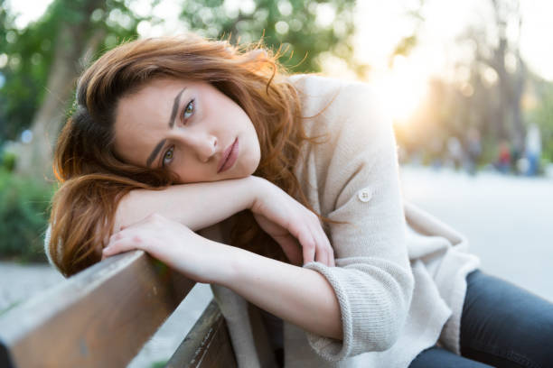 istock Unhappy girl sitting at bench 1030071624