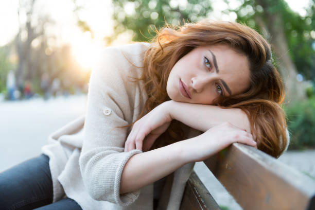 istock Unhappy girl sitting at bench 1030071628