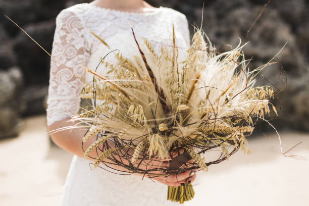 istock Wedding bouquet with dried flowers and spikelets Boho style in brides hands 1030071806